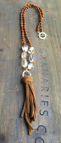 Beaded necklace with clear quartz and natural wood beads with leather tassel and toggle clasp