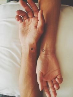 X and O matching wrist tattoos.