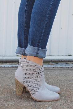 Our Tailgates & Tanlines Bootie is a pair of almond toe dove grey booties with perforated sides, side zipper and stacked wooden heel.