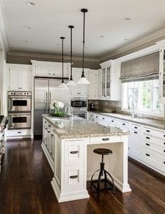 Just about perfect! Dark walls, white cabinets, dark traditional pulls, mid-tone granite. Love the style of the pendants and the use of glass.